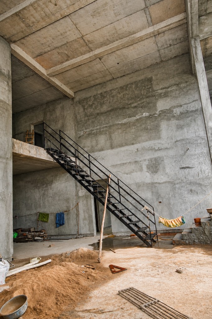 Interior structural framing with metal stairs and sand preparation on site